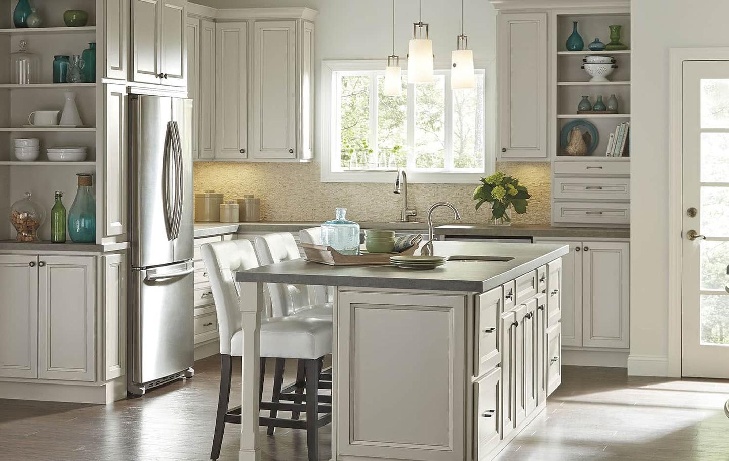 Bright white kitchen remodel with a large island, pendant lights and custom cabinetry by Seghi Renovations in South Lyon, Michigan